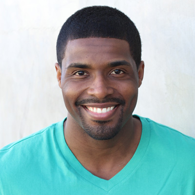 The image shows two elderly individuals, an older man and woman, posing for a photo with smiles on their faces. They are embracing each other and seem to be enjoying a moment together outdoors.